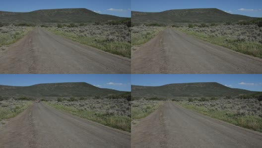 沙漠中长长的土路，远处有摩托车高清在线视频素材下载