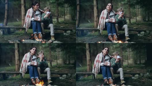 母亲和儿子在森林篝火旁唱歌喝茶高清在线视频素材下载
