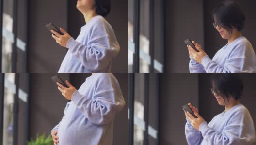 一名中国孕妇正站着使用手机高清在线视频素材下载