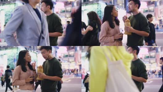 SLO MO手持中景拍摄一对年轻夫妇在香港吃传统街头小吃高清在线视频素材下载