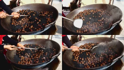 Chestnuts roasting in pan with hot black sand.高清在线视频素材下载