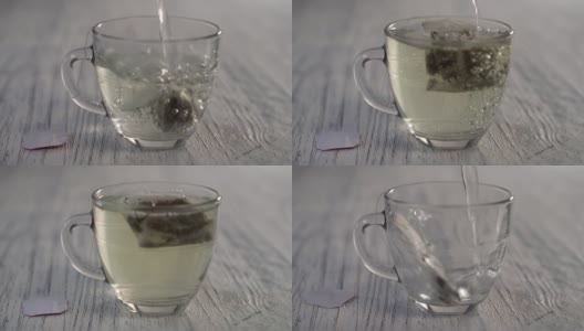 热水倒进一个玻璃杯子里，杯子里放着一袋凉茶，放在一张灰色的木制桌子上。高清在线视频素材下载
