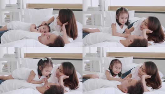 幸福的亚洲家庭生活方式在家里，爸爸和妈妈和女儿在早房玩，父母和孩子在床上玩得很开心高清在线视频素材下载