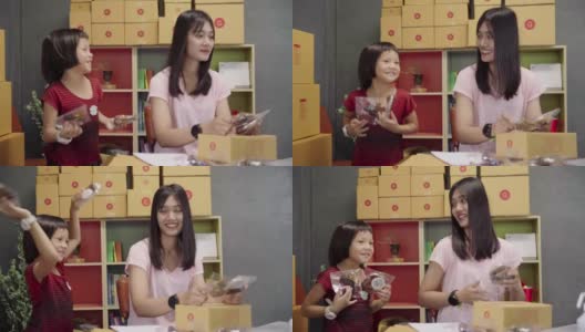 亚洲妇女和小女孩展示和包装盒集装箱网上销售在家里。高清在线视频素材下载