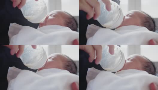 近景母亲喂养她可爱可爱的小新生儿婴儿从奶瓶喝牛奶躺在母亲的手，幸福的家庭概念高清在线视频素材下载