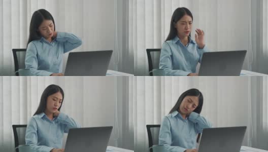 一位年轻的亚洲女性正坐在公司的办公室里，脖子很疼。高清在线视频素材下载