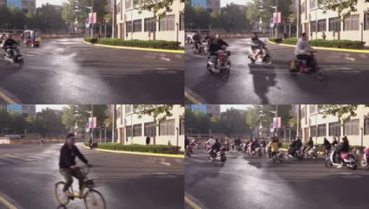 一群摩托车、踏板车和自行车在绿灯信号下穿过街道，这是中国城市上海的典型交通高清在线视频素材下载