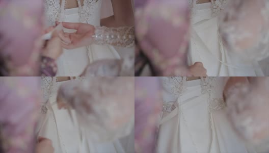 男人在新娘的婚纱上系紧身衣高清在线视频素材下载