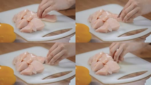 女厨师在切菜板上切生鸡肉。高清在线视频素材下载