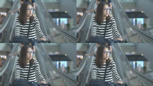 在机场的自动扶梯上行走的年轻女子高清在线视频素材下载
