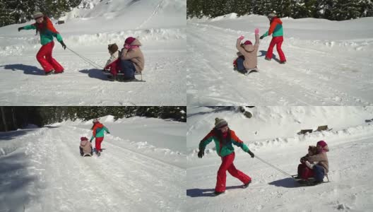 快乐的家庭在冬天的雪山森林里玩耍。妈妈和她的两个孩子在玩雪橇。他们笑了。高清在线视频素材下载
