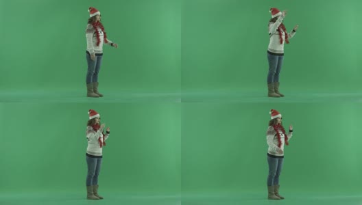 迷人的年轻女子戴着圣诞帽，使用虚拟触摸屏技术，背景色键高清在线视频素材下载