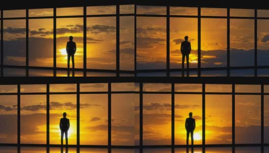 这个男人站在日落背景的全景窗户旁。时间流逝高清在线视频素材下载