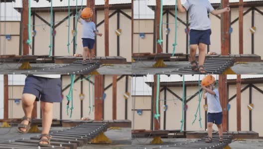婴儿在街上的一个绳子小镇上玩。一个男孩在儿童器材上行走。一个孩子在操场上走在摇摇欲坠的木桥上。高清在线视频素材下载