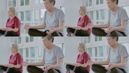 亚洲老年夫妇做冥想瑜伽在家锻炼。采购产品家庭，生活方式，人，老年人，关系，退休，健康护理，领导，老年人在体育概念。高清在线视频素材下载