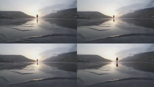 日出时穿过浅湖的人高清在线视频素材下载