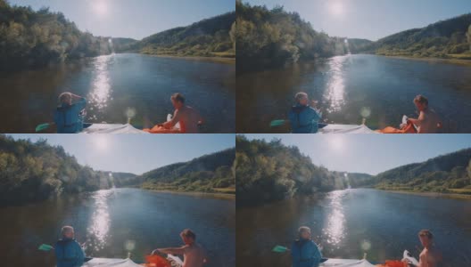 家庭漂流。在炎热的夏天，一家人坐在木筏上沿着平静的浅河漂流高清在线视频素材下载