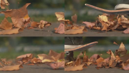 慢镜头:一个不认识的人滑过一堆五颜六色的秋叶。高清在线视频素材下载