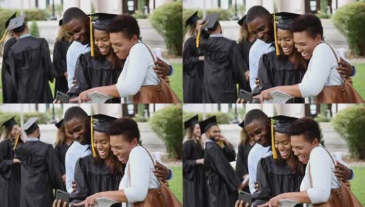 大学毕业生和父母一起看毕业照高清在线视频素材下载