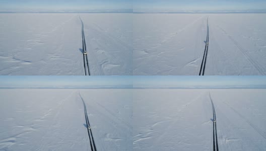 无人机跟踪一辆在冰上行驶的汽车。美丽的冬天的风景高清在线视频素材下载