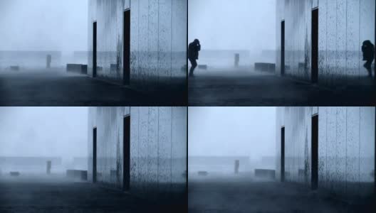 冰岛雷克雅未克，一名男子在暴风雪中进入大楼高清在线视频素材下载