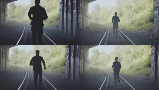 慢镜头男人在铁轨上奔跑的剪影。后视图。抽象背景结束镜头。追求自由高清在线视频素材下载