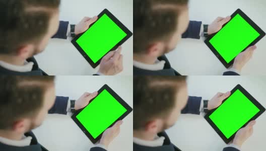 一名男子使用绿色屏幕的数字平板电脑高清在线视频素材下载