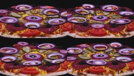 特写自制披萨与泡菜和新鲜洋葱旋转在黑色背景高清在线视频素材下载