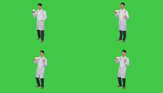 医生拿着一盒药丸宣传他们，并在绿色屏幕上跳舞，色度钥匙高清在线视频素材下载