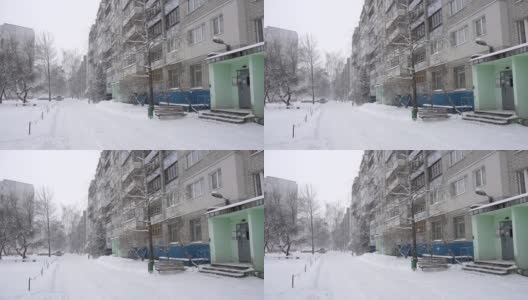 雪落在一座多层城市的住宅庭院里，背景、冬季、慢镜头高清在线视频素材下载