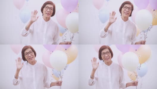 快乐的亚洲资深妇女与气球。老年人生日或周年聚会概念高清在线视频素材下载