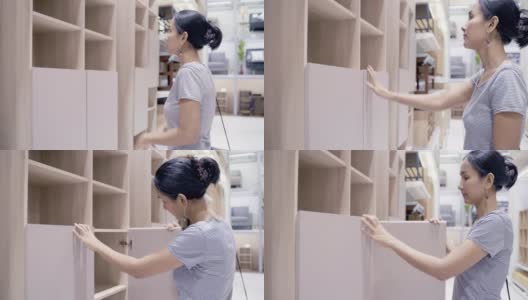 亚洲女性顾客购买和选择桌子和书架木材家居装饰。亚洲女性在商店购买五金和家具。高清在线视频素材下载
