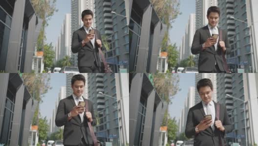 亚洲商人站在城市的街道上和他的同事在电话聊天，在你早上的通勤。高清在线视频素材下载