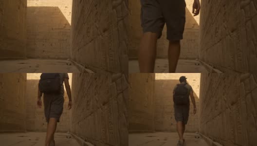 一个年轻人正在穿过Edfu寺和它美丽的象形墙壁。埃及。在尼罗河河畔的Edfu城附近的阿斯旺，希腊罗马建筑，献给荷鲁斯高清在线视频素材下载