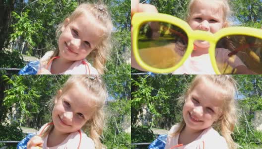 微笑的小女孩看着相机的肖像。快乐可爱的孩子在夏日公园户外玩耍，享受童年时光高清在线视频素材下载