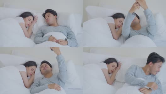 亚洲魅力有趣的男性自拍与睡觉的女友在床上。幸福的家庭，新婚夫妇一起度过早上的时间，丈夫躺在卧室里给妻子拍照。高清在线视频素材下载