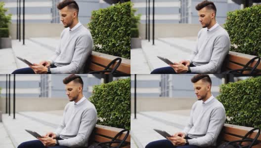一个人拿着平板电脑坐在城市街道的长椅上高清在线视频素材下载
