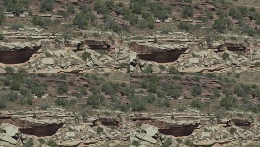 两个人在科罗拉多州大Junction沙漠的科罗拉多国家纪念碑的岩石边缘上行走的航拍照片高清在线视频素材下载