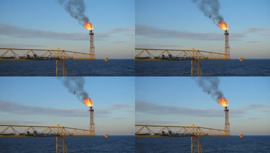 慢动作的气体火炬燃烧在海上的油气平台上，在海与蓝天为油气行业的概念。高清在线视频素材下载
