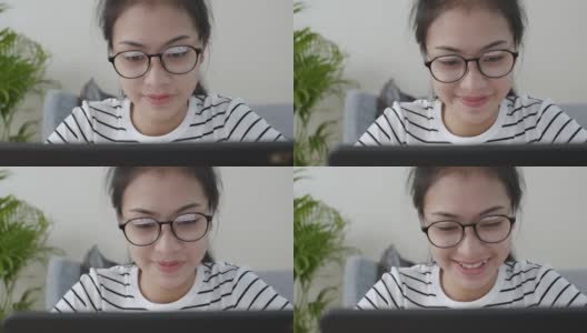 特写亚洲女人的脸戴上眼镜，用笔记本电脑和快乐的微笑，在线学习在家的概念高清在线视频素材下载
