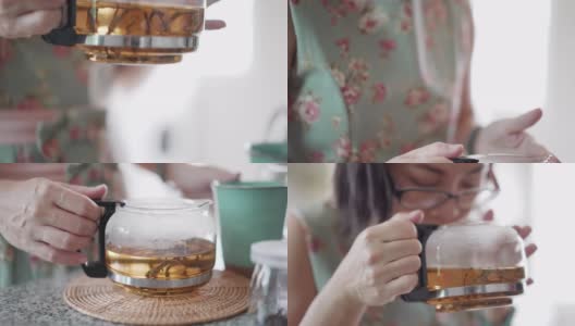 亚洲妇女拿着茶壶，闻着热茶的香气在家里放松高清在线视频素材下载
