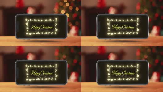 木制表面智能手机屏幕上显示圣诞快乐文字和童话灯的动画高清在线视频素材下载
