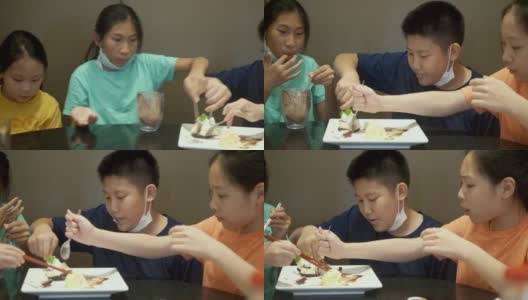 四个亚洲孩子一起在餐厅吃冰淇淋蛋糕庆祝生日，生活理念。高清在线视频素材下载