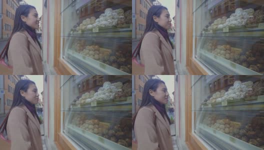 一个东南亚女人从窗口看蛋糕高清在线视频素材下载