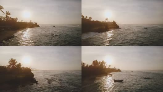 不可思议的航拍美丽的日落海岸线，海浪反射夕阳，到达异国情调的热带海岸高清在线视频素材下载