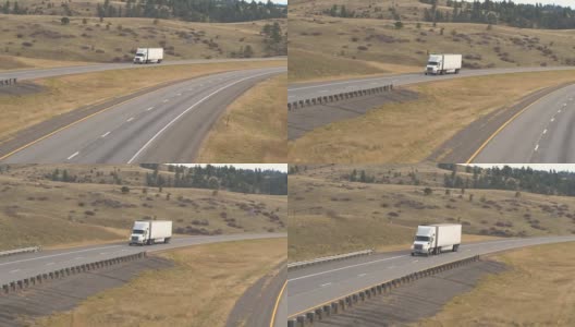空中近距离拍摄在美国大平原上运送货物的白色半卡车高清在线视频素材下载