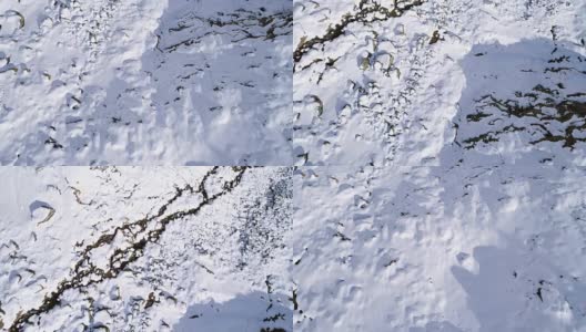 高空飞过雪山，山脊，山谷建立者向前飞行。户外雪高山野生自然景观在冬季顶视图与阳光和阴影。4k无人机飞行建立镜头高清在线视频素材下载