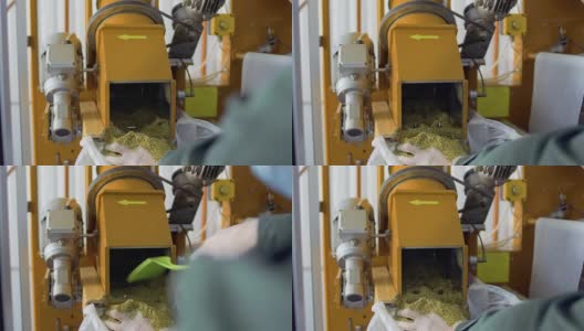 茶厂工人将凉茶从机器中铲入袋中高清在线视频素材下载