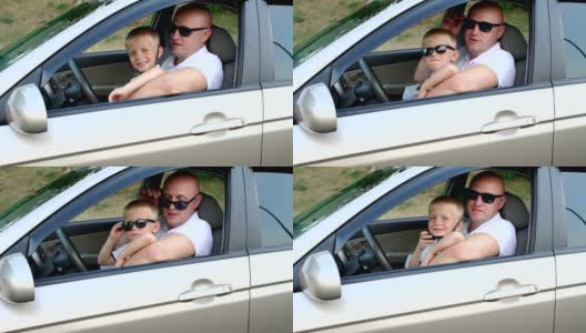 一个严肃的男人和他穿着白色t恤的儿子坐在车里高清在线视频素材下载