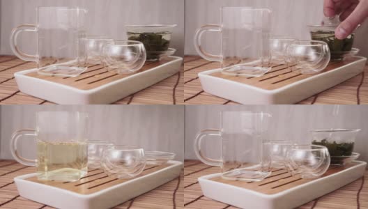将中国绿茶从玻璃茶壶倒入一个小杯子中高清在线视频素材下载